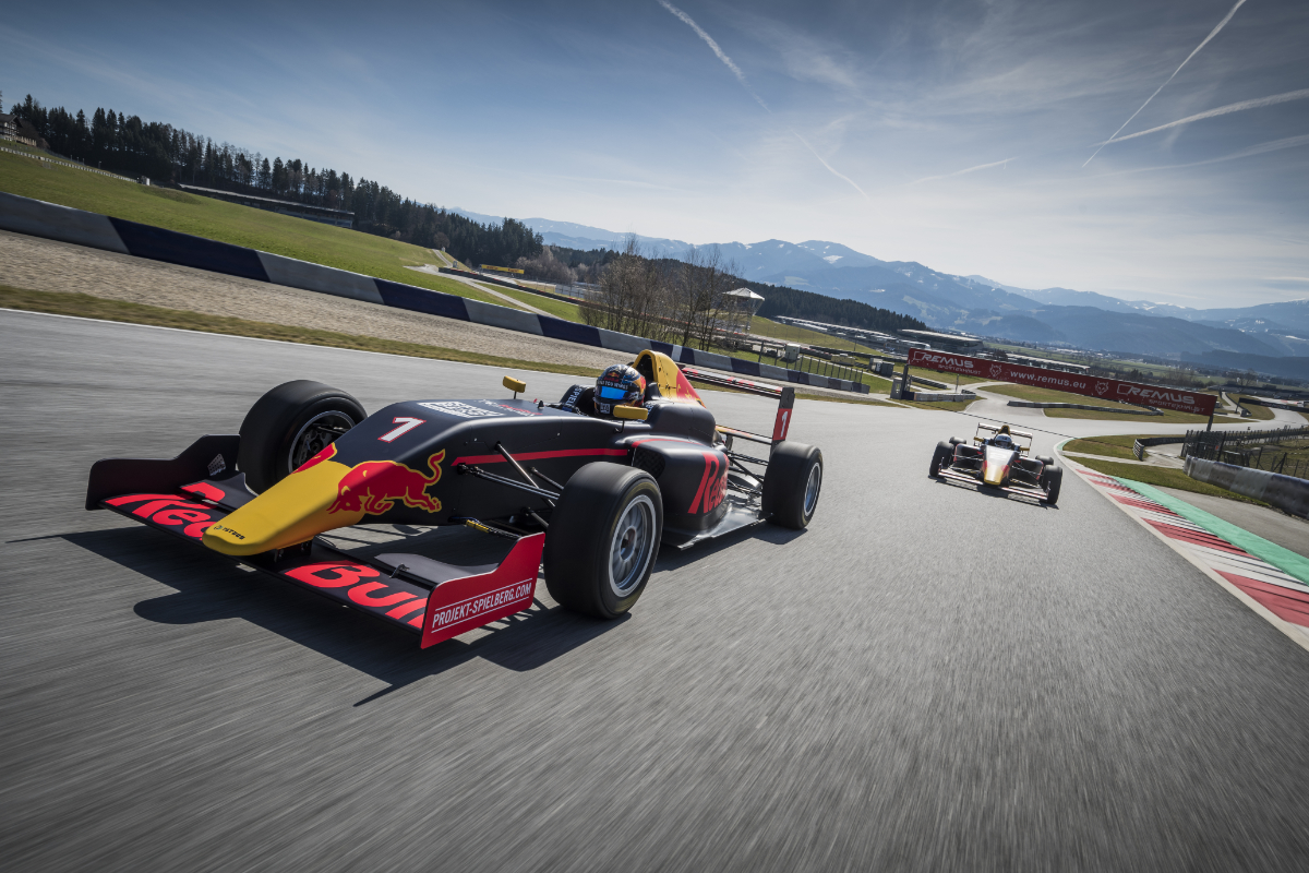 Formel Auto auf Rennstrecke mit Bergen im Hintergrund