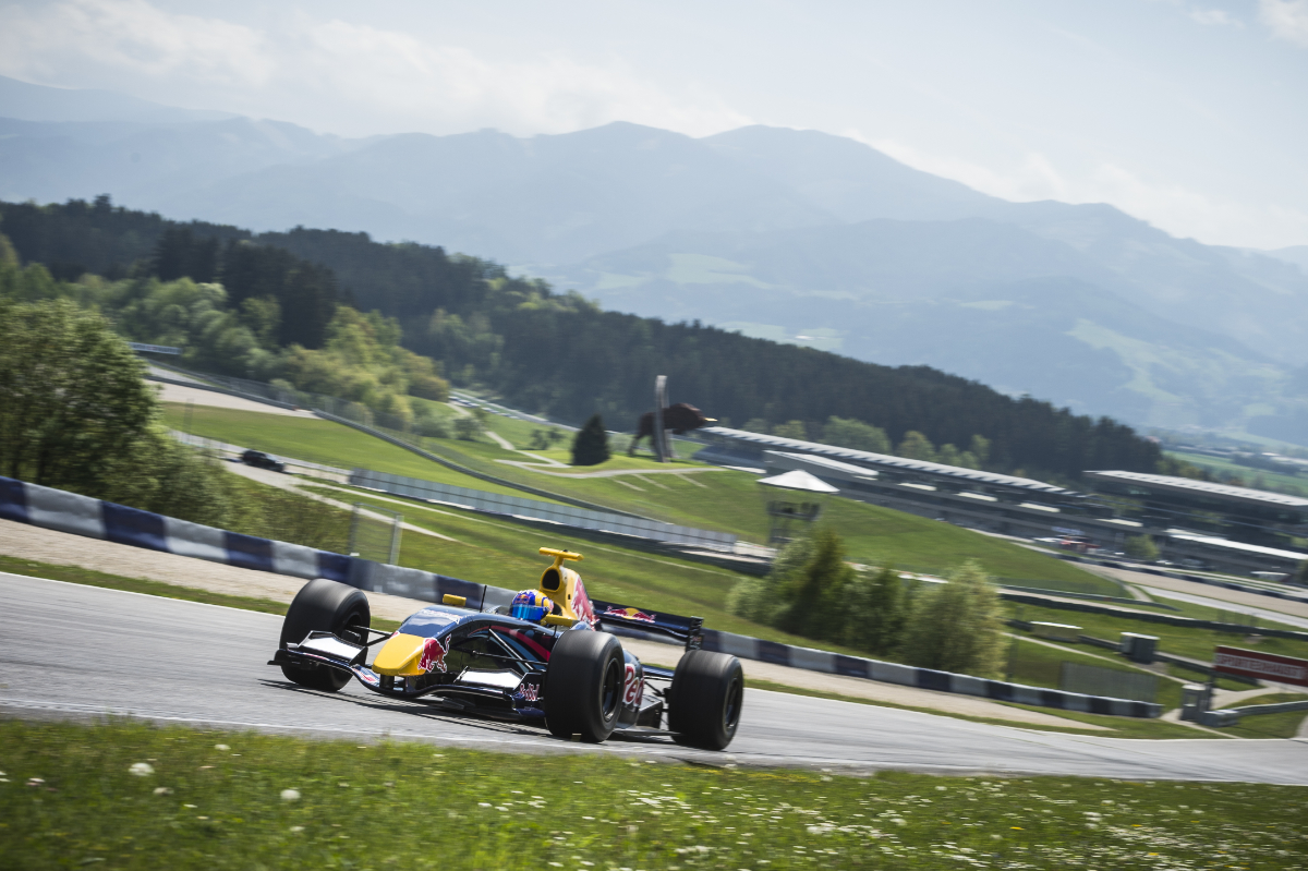 Formel Auto von Renault auf Rennstrecke mit Bergen im Hintergrund